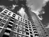 黑白图像中，现代摩天大楼映衬着引人注目的云层