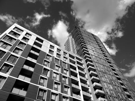 黑白图像中，现代摩天大楼映衬着引人注目的云层