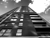 现代摩天大楼的黑白景观，在多云的天空映衬下，呈现出反光玻璃与钢铁建筑的结构