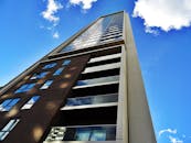 低角度视角下的现代摩天大楼，玻璃窗与钢结构映衬着清澈的蓝天