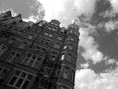 在多云的天空映衬下，一座高大的历史建筑呈现出单色视图，展现了城市建筑的特色