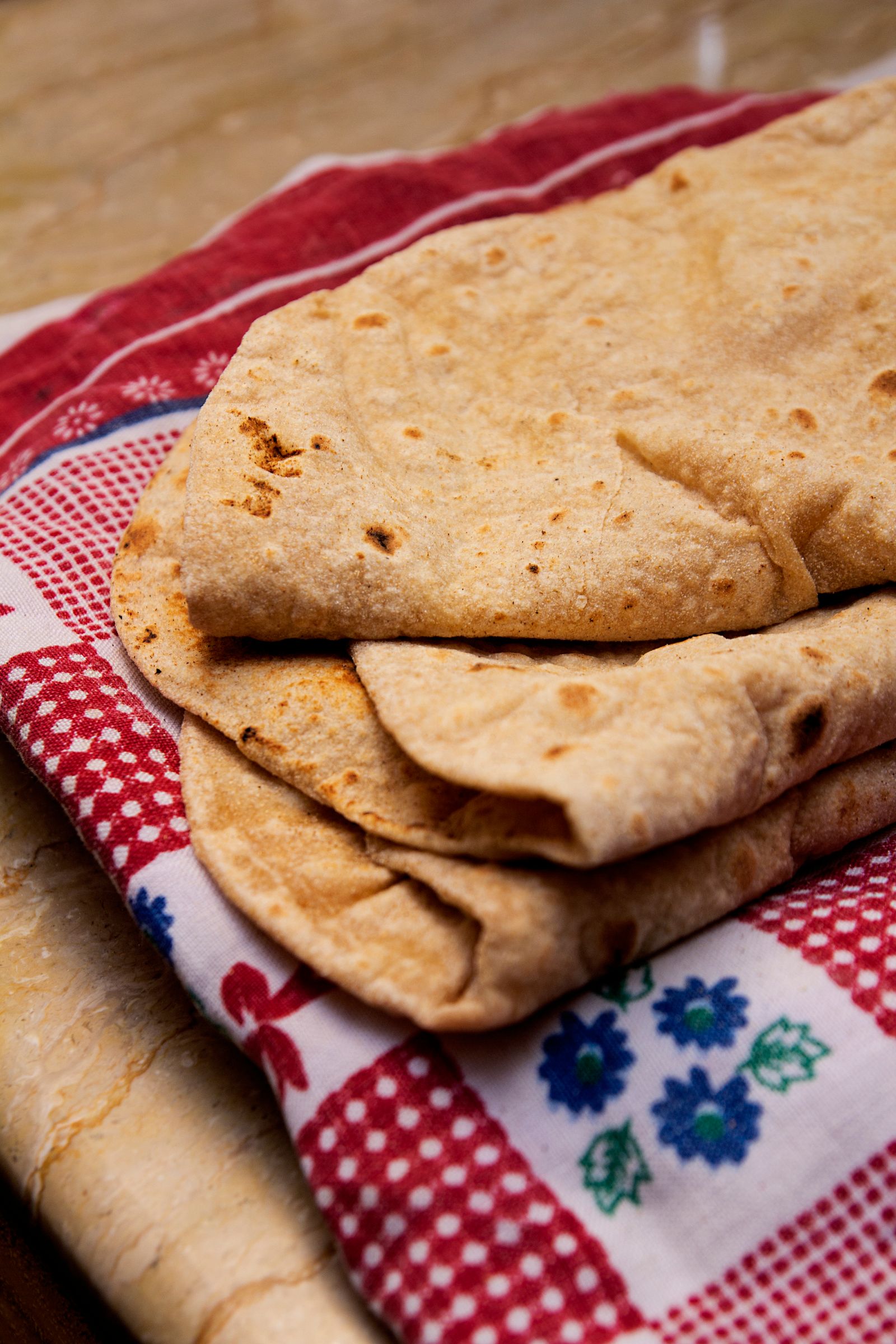 Fresh hot rotis on a wooden serving board