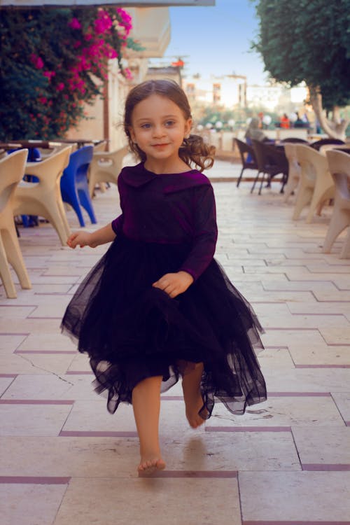 Girl in Violet Sheer Dress Running on Pavement 