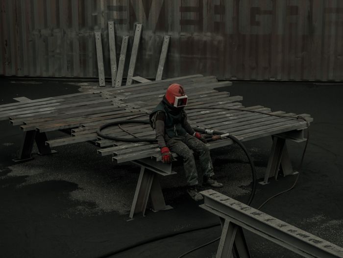 Worker in protective gear on structural steel at an industrial site