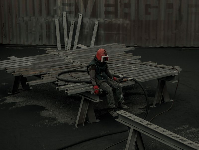 Crew resting on steel beams at an industrial site