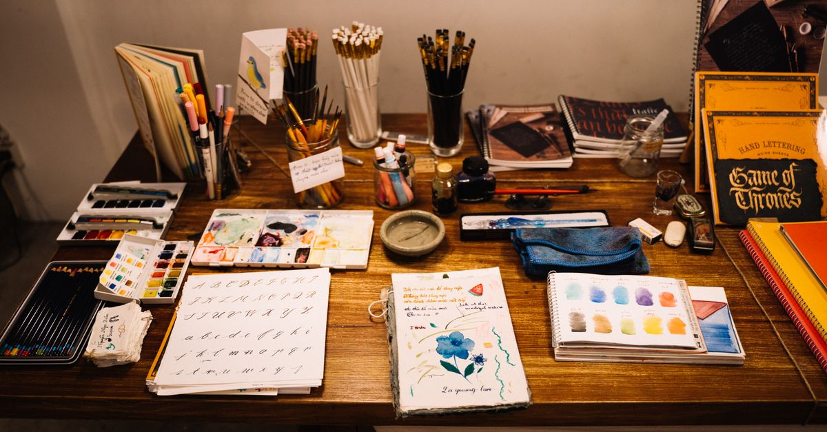Explore a neatly arranged artist's workspace filled with drawing materials and sketchbooks.