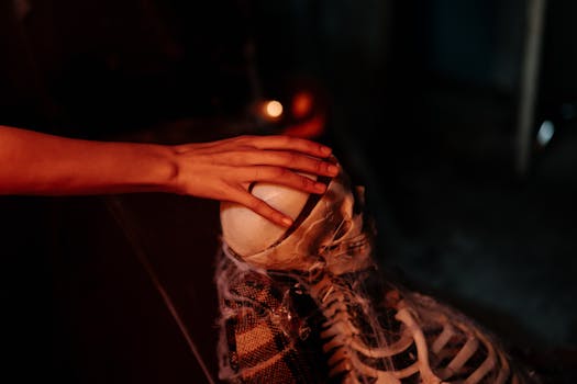 A spooky hand resting on a skeleton with spider webs, perfect for Halloween themes.