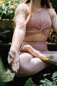 Woman meditating outdoors in lotus position, capturing tranquility and peace.