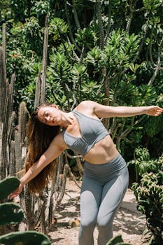 Woman in activewear performing yoga in a cactus garden, embracing nature and wellness.