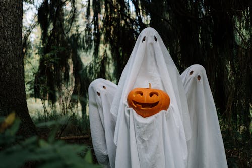 Ghosts Holding a Carved Pumpkin