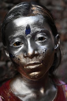 Close-up portrait of a woman with creative metallic makeup outdoors.