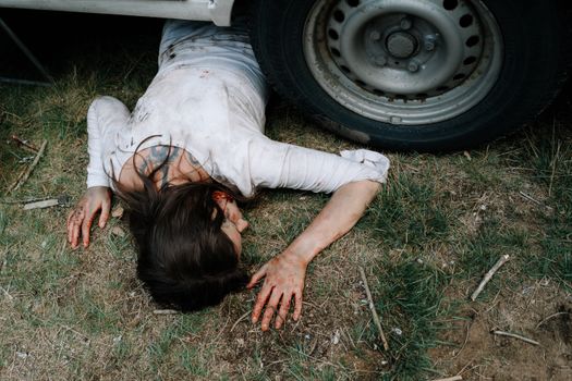 Dead Woman lying underneath a Car 