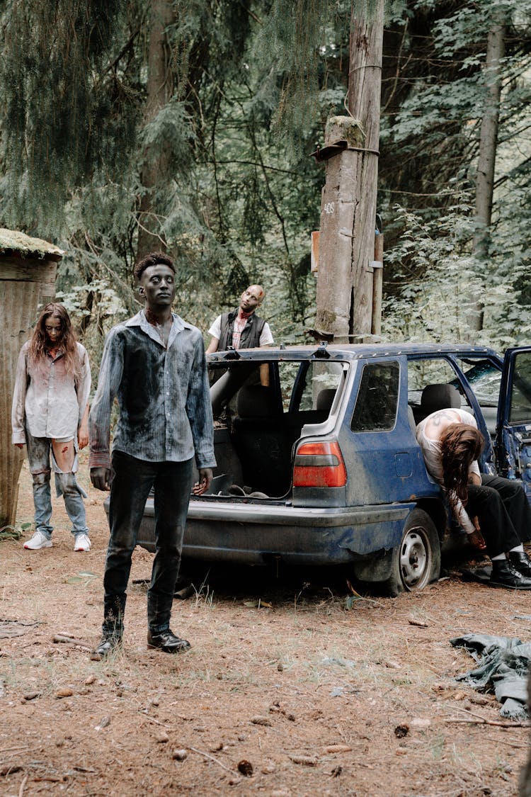 Zombies Standing Beside An Old Car