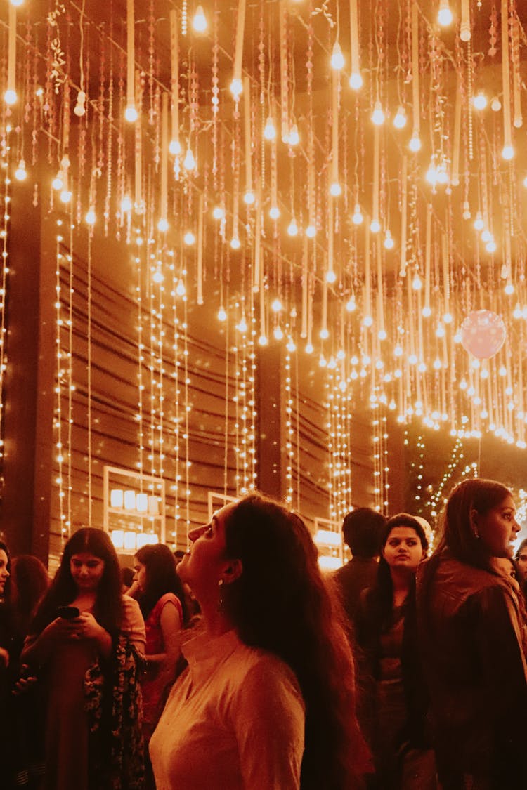 Woman Looking Up At Hanging Lights 