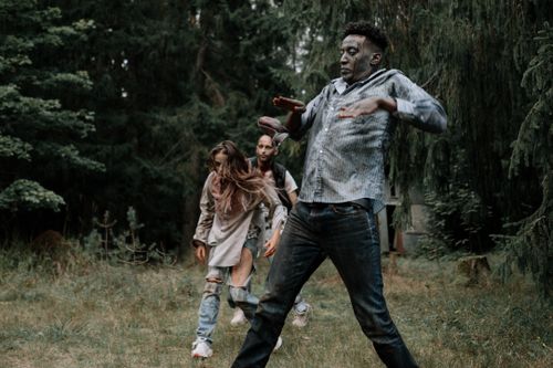Free Terrifying zombies stumbling through a dark, creepy forest setting, perfect for horror themes. Stock Photo