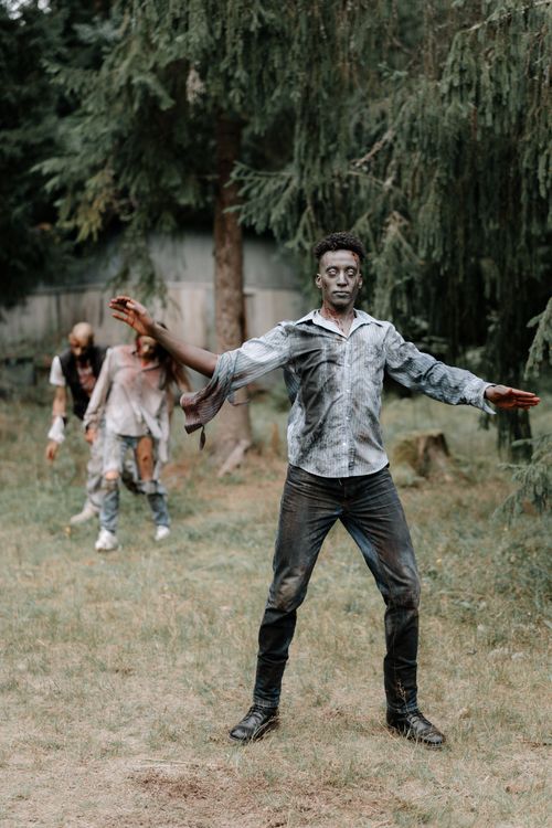 Free Photo of costumed zombies walking through a forest, capturing a haunting atmosphere. Stock Photo