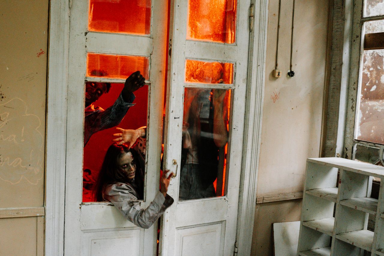 terrifying scene of zombies trying to enter through a doorway in an ab