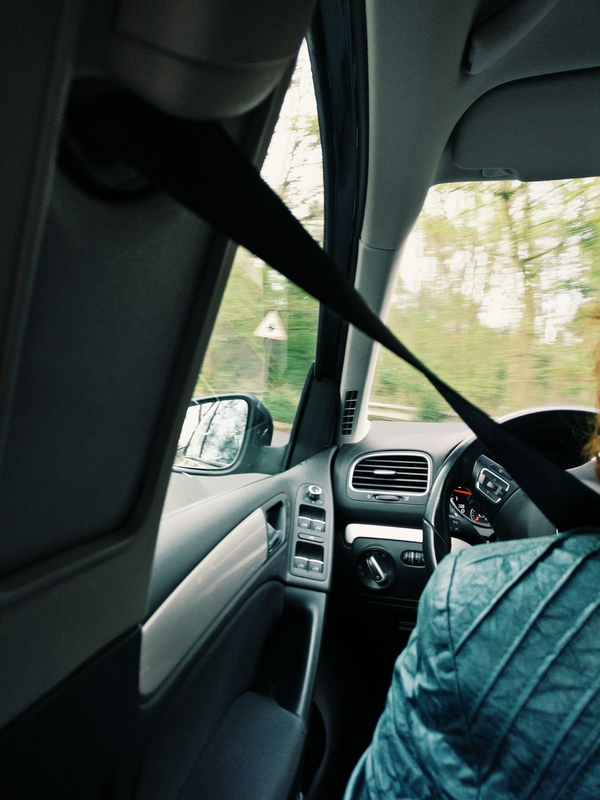 Interior de coche moderno con cinturón de seguridad visible, donde debe estar accesible el martillo rompe cristales de emergencia