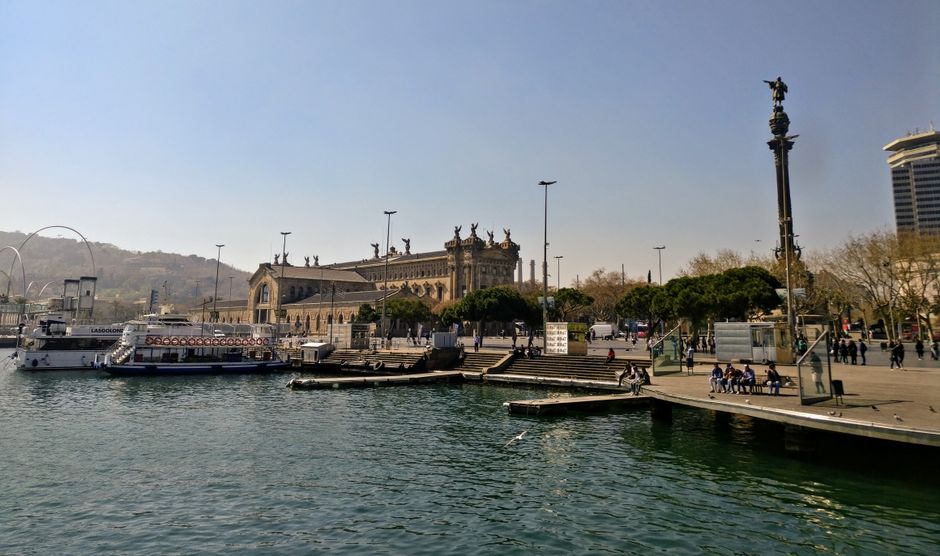 Hermosa vista del área portuaria de Barcelona con arquitectura histórica y actividades en el waterfront.