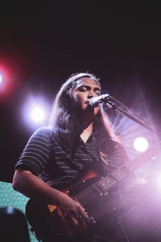 Energetic live performance featuring a musician playing electric guitar and singing passionately.