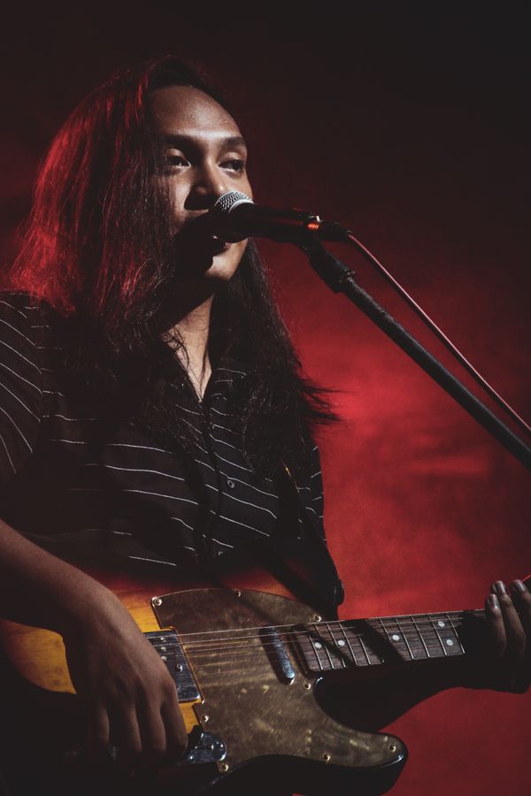 Featured artist singing on stage, photo by John Ric Cabatuan on Pexels
