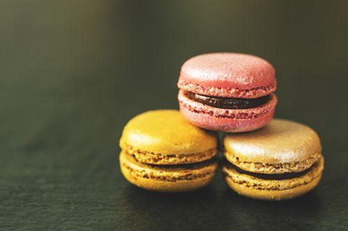 Free Three vibrant macarons stacked on dark slate, showcasing a delicious treat. Stock Photo