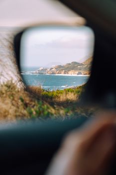 海岸景观在车侧镜中反射，前景模糊，捕捉到宁静的旅行时刻。 - 相关推荐