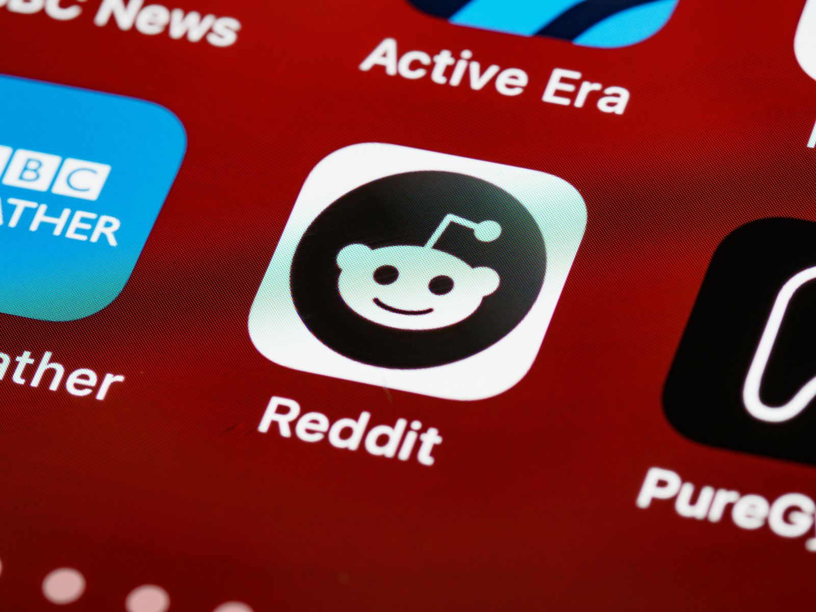 A smartphone showing the Reddit app icon on its home screen