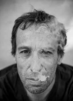 一幅描绘男子吸烟的黑白肖像，情绪多变，展现了沉思与张力