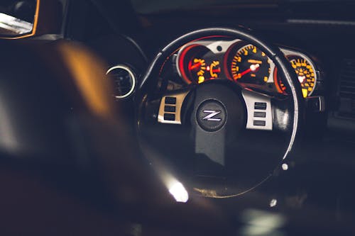 Free Contemporary auto interior with shiny steering wheel and bright instrument panel near leather seat in evening Stock Photo