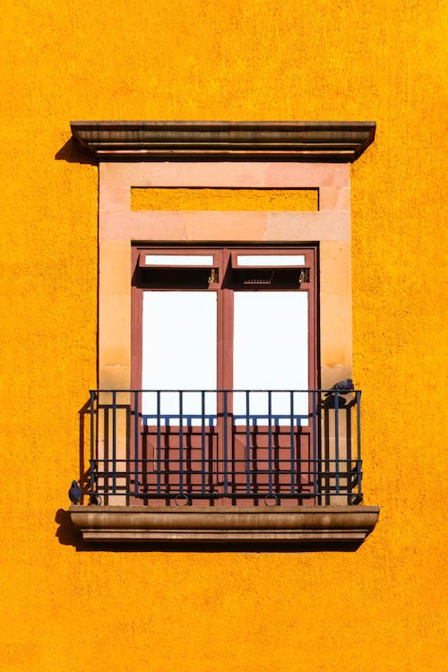 Free Aged balcony on bright wall Stock Photo