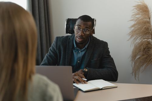 Free Businessman conducting a formal interview in a modern office environment. Stock Photo