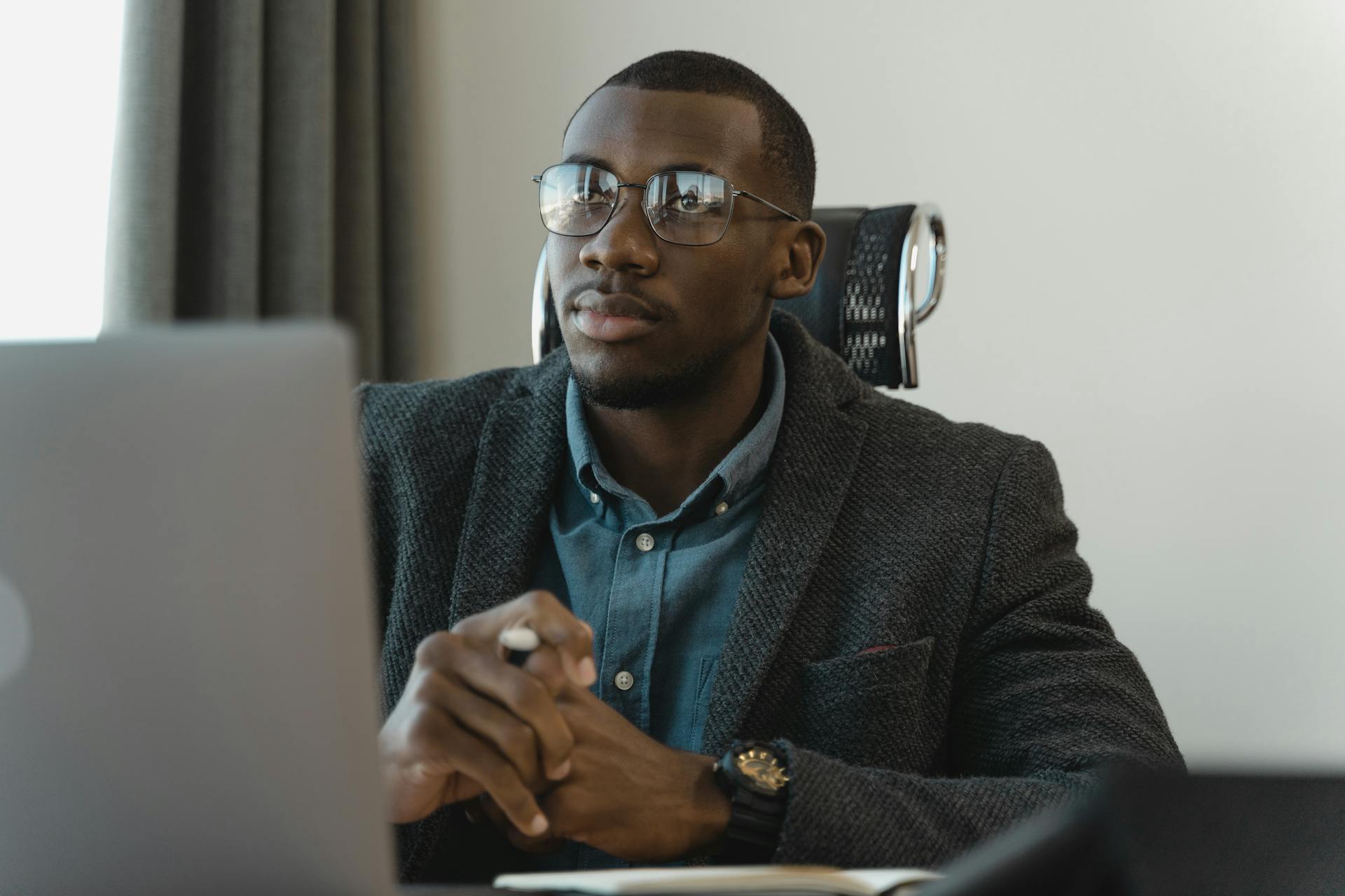 Focused businessman in corporate attire working at his desk with a modern laptop.