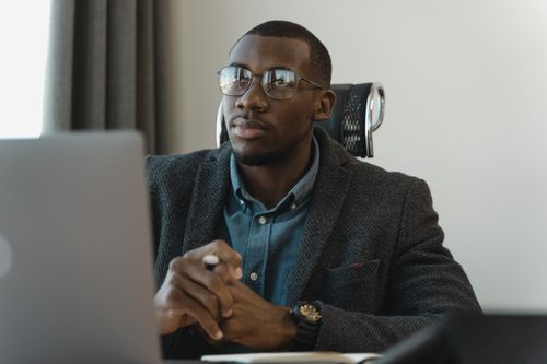 Free Focused businessman in corporate attire working at his desk with a modern laptop. Stock Photo