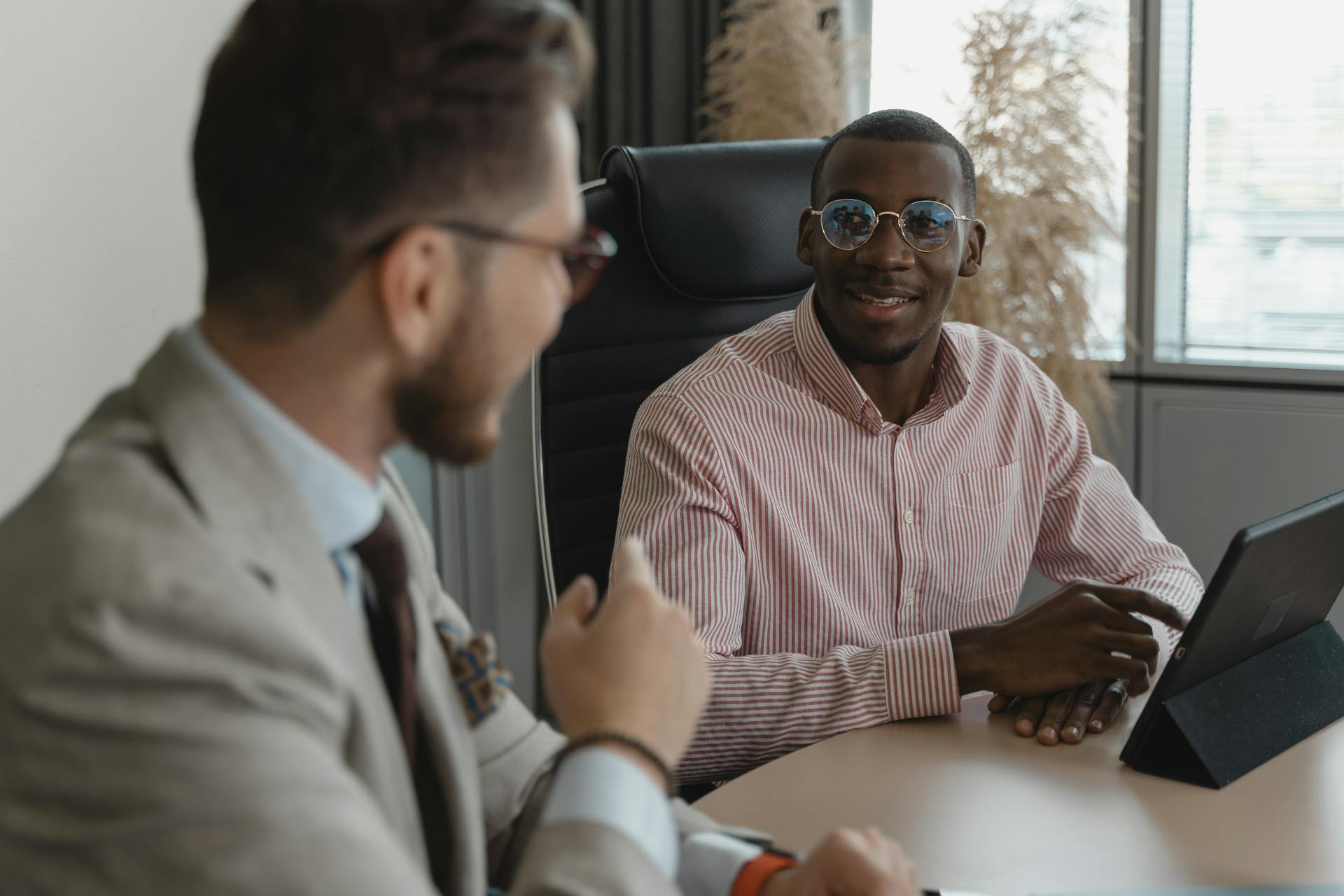 Two candidates in a professional setting during a job interview, engaging in conversation.