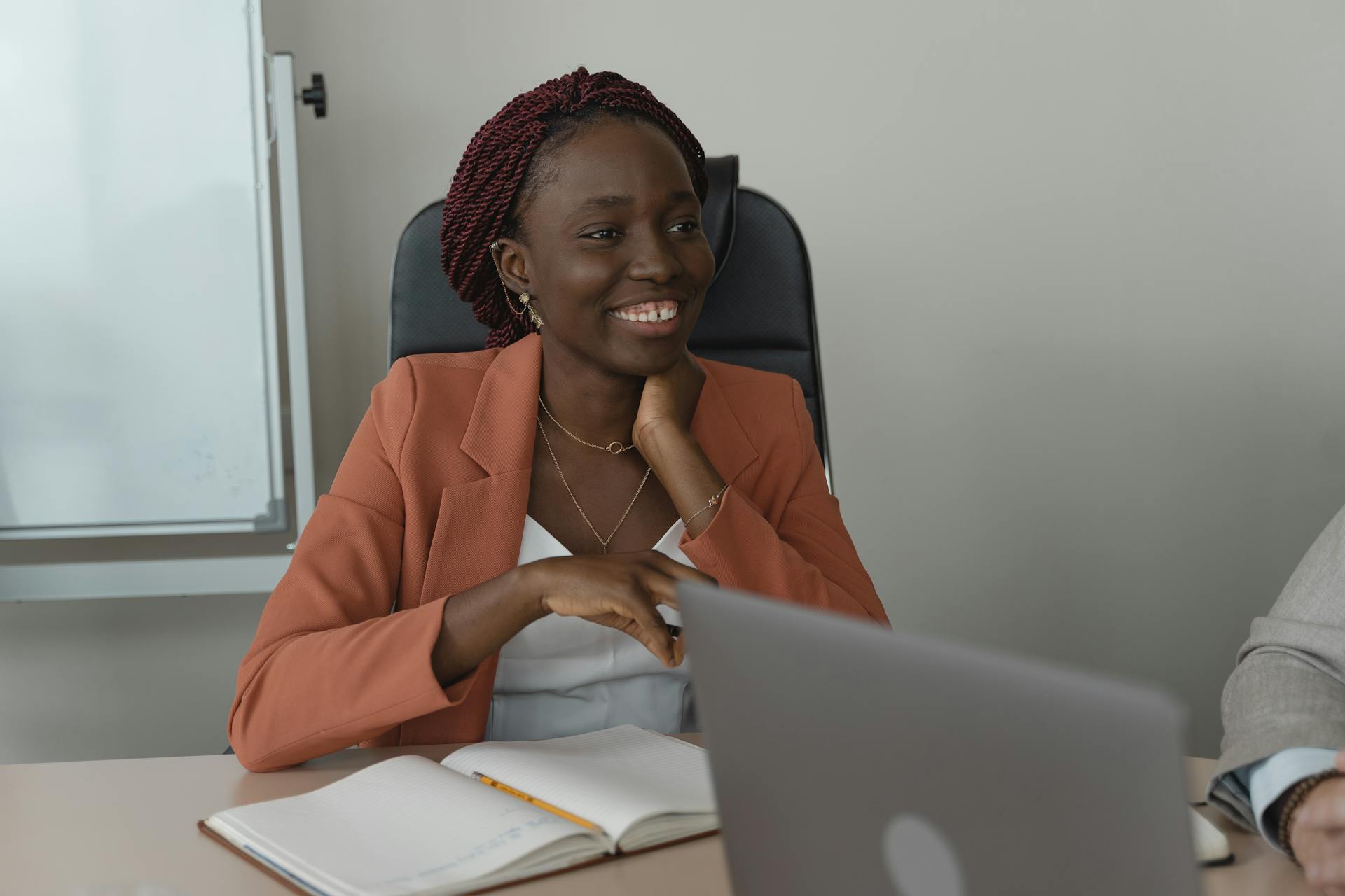 Businesswoman smiling during a corporate meeting indoors.