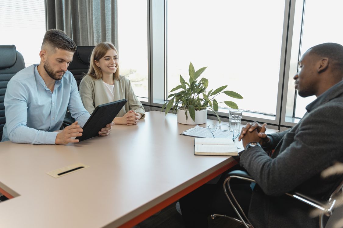 Free A business interview with three people in a modern office room, highlighting collaboration. Stock Photo