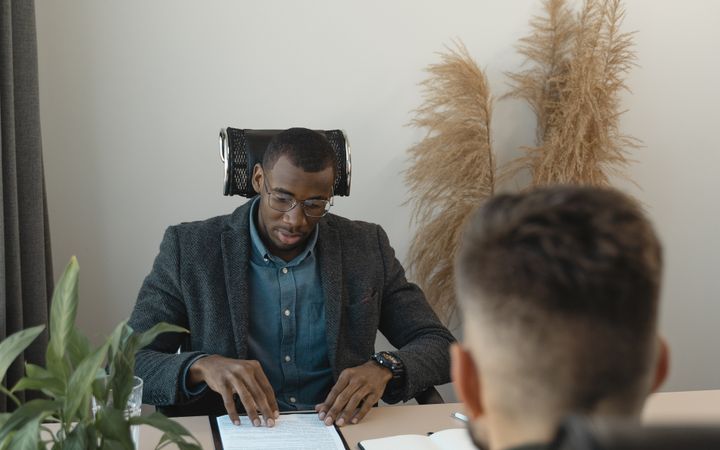 Two professionals engaged in a job interview in a modern office setting with greenery.