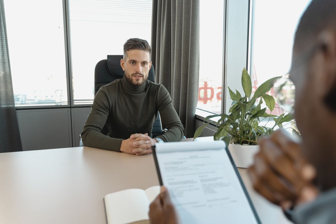Professional recruiter interviewing a candidate in a modern office setting.