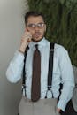 Man in Formal Attire Wearing Black Framed Eyeglasses while Having a Phone Call