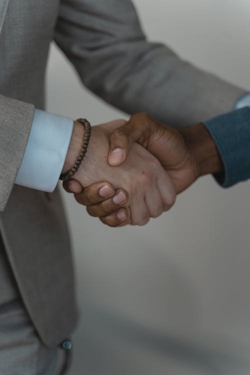 Close-up Photo of Two People doing Handshake 