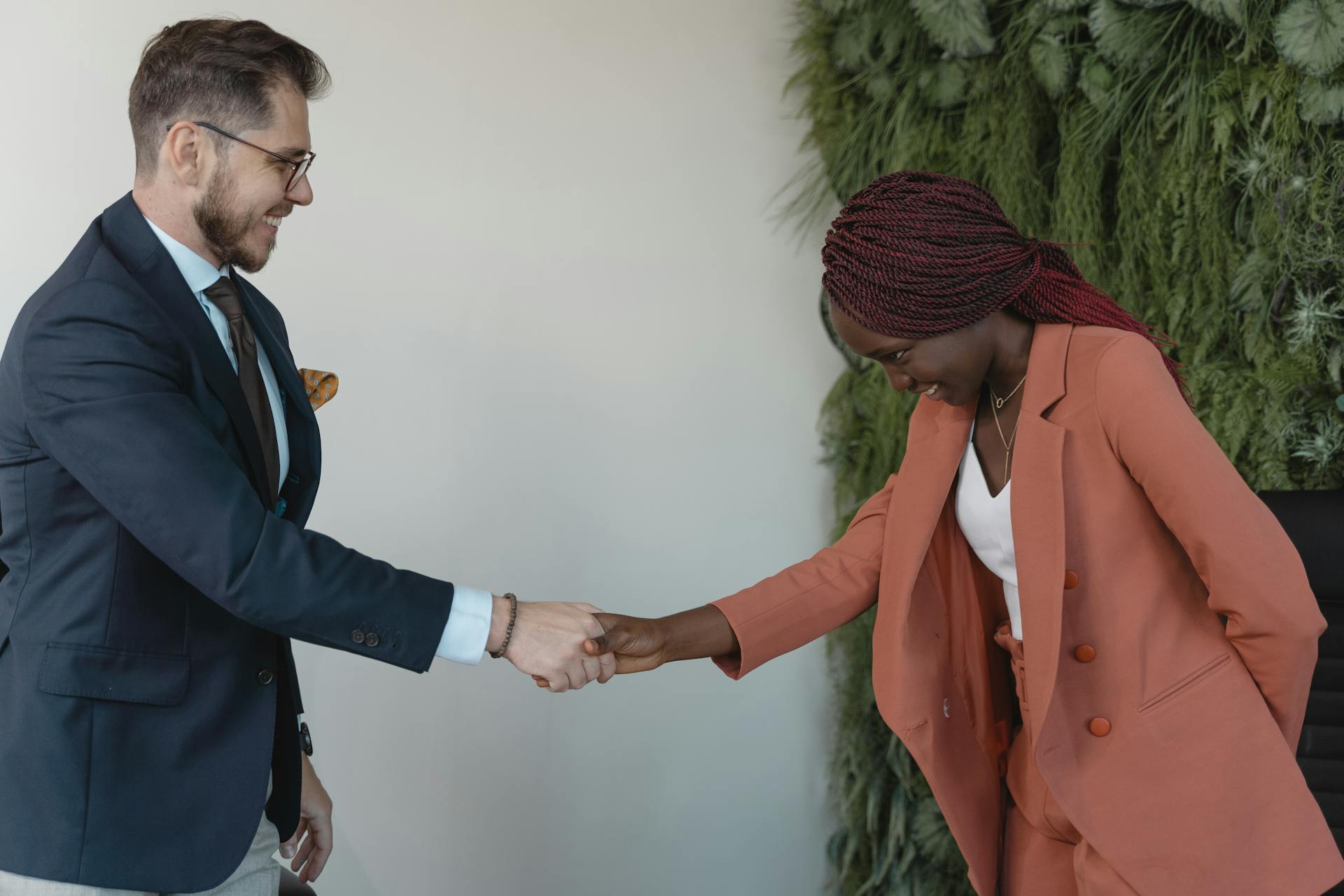 A business handshake between two professionals in a corporate setting, symbolizing successful agreement.