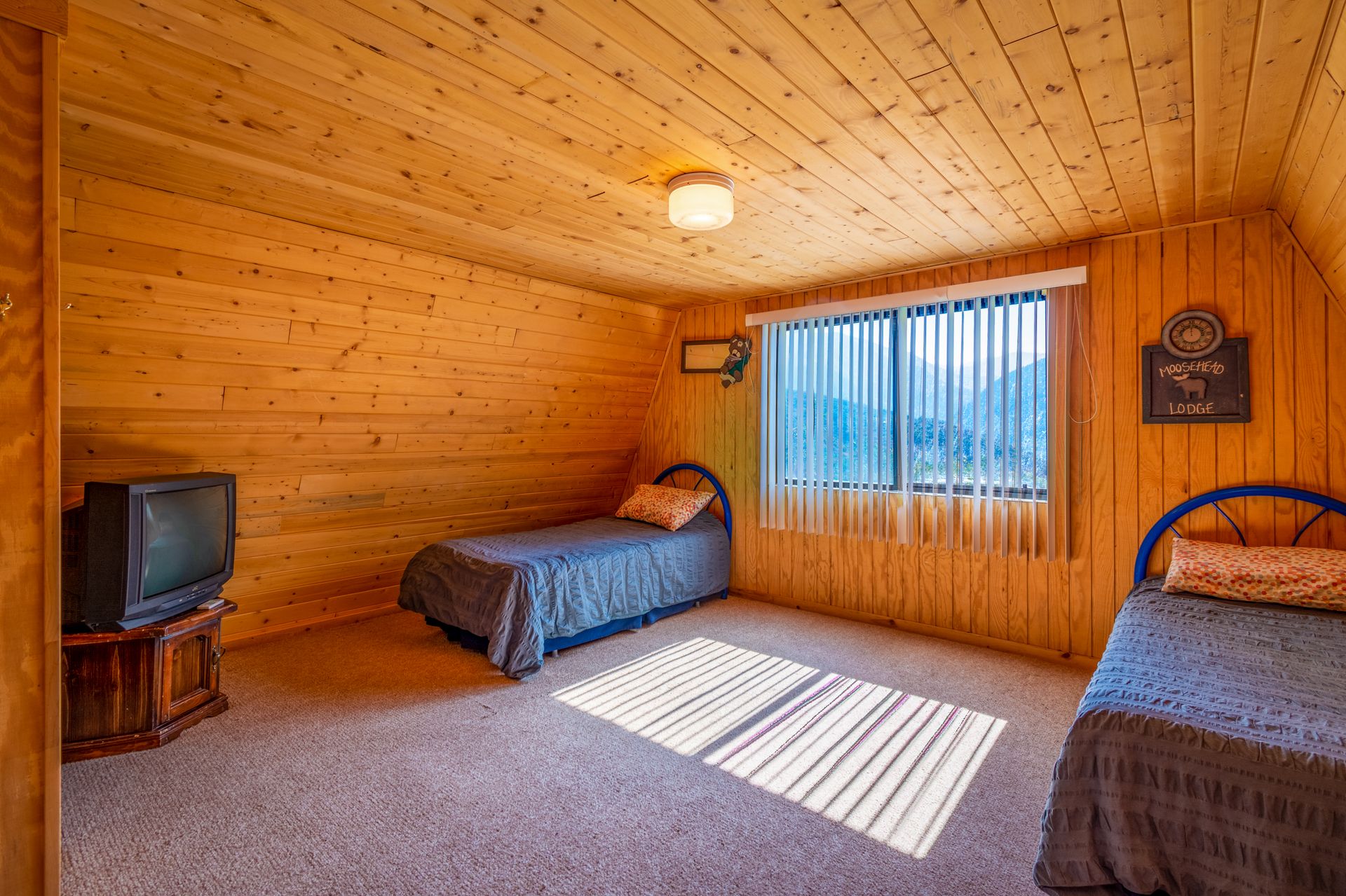 Comfortable wooden cabin bedroom with large window and twin beds.