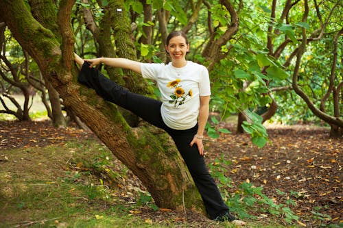 Woman in White T-shirt and Black Pants Climbing on Tree