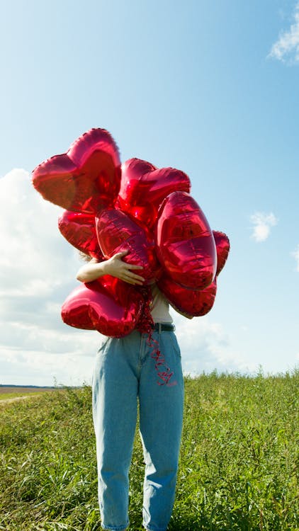 A Person Holding Red Balloons