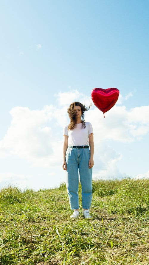 A Woman Standing on the Grass Field