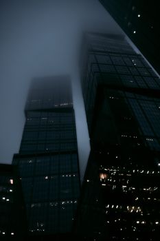夜间笼罩在雾中的莫斯科摩天大楼，呈现出忧郁的景色，展示了城市的建筑风貌