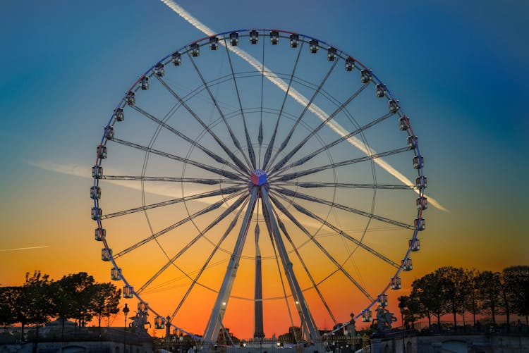 Ferris Wheel In Amusement Park At Sunset