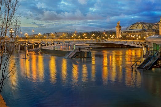 Picturesque view of bright glowing lights on embankment near pier and modern constructions on water in city