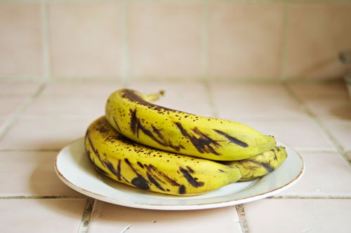 Free Close-up of ripe bananas with dark spots on a ceramic plate indoors. Perfect for healthy food concepts. Stock Photo